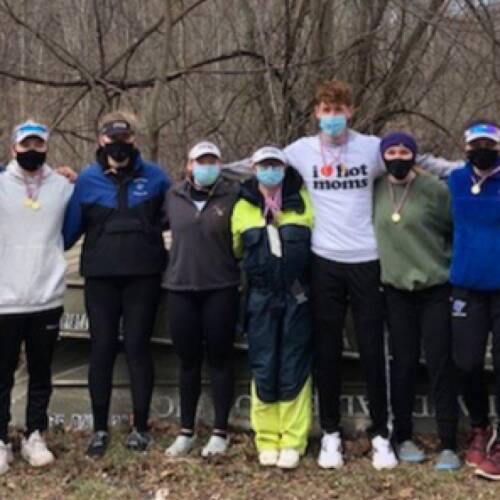 Rowing athletes pose before taking to the water with teammates.